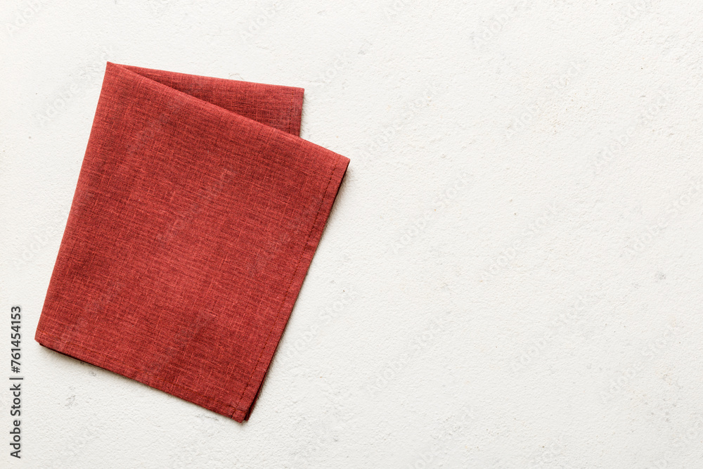 Fototapeta premium top view with red empty kitchen napkin isolated on table background. Folded cloth for mockup with copy space, Flat lay. Minimal style