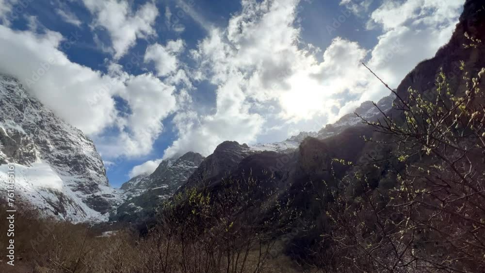 Midagrabin Valley. The gorge of the mountain river in the Midagrabin valley. The beautiful valley of the Midagraba waterfalls in spring. The tract is surrounded by rocky and misty peaks. 4K