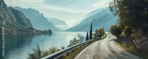 Countryside roadway between mountains and calm lake photo