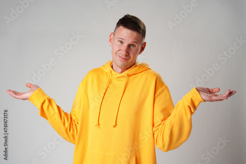 Portrait of confused clueless man on gray background in studio