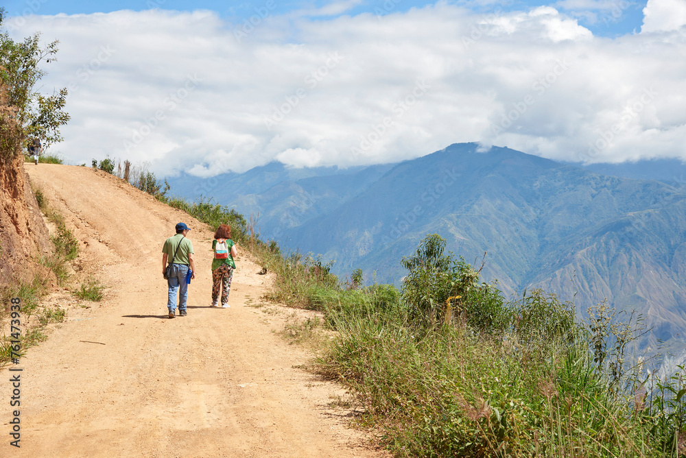 Senior couple walking along a rural Andean road up a mountain in Santander, Colombia.