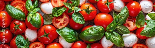 A bunch of ripe tomatoes and fresh basil leaves neatly arranged on a table