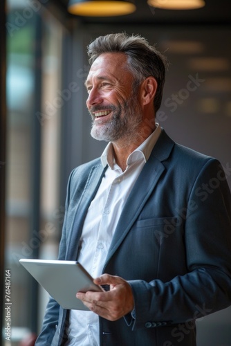 A man in a suit holding a tablet computer, suitable for business concepts