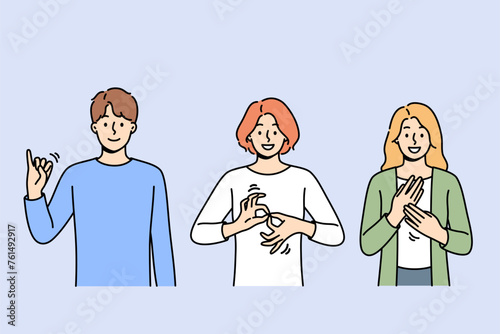 Deaf and mute people use sign language to communicate by making different gestures. Guy and two girls are learning sign language to be able to communicate with humans with disabilities