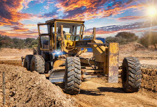 yellow grader digging the earth on a construction site at a diamond mine photo