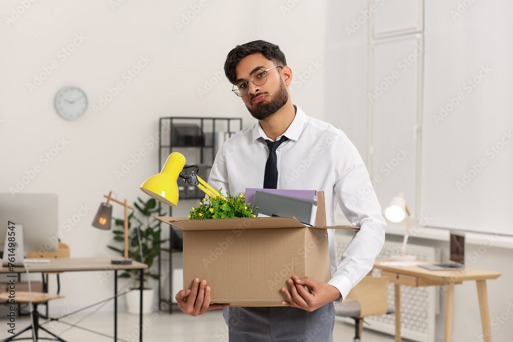 Unemployment problem. Frustrated man with box of personal belongings in office Unemployment problem. Frustrated man with box of personal belongings in office
