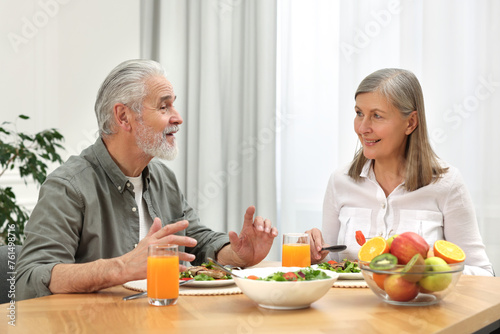 Happy senior couple having dinner at home