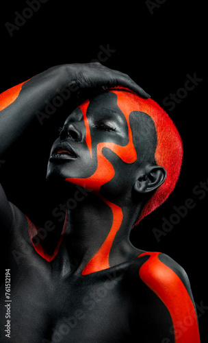 The Art Face. Close-up portrait. Black and yellow body paint on african woman. Abstract creative portrait. Bright fashion makeup on the girl.