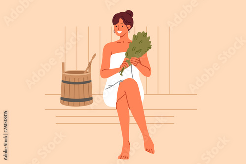 Woman sits in bathhouse and smiles, enjoying thermal treatments that improve well-being and get rid of toxins. Girl visitor to bathhouse holds birch broom located near wooden bucket