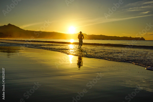 a man fishing on the beach at sunrise  © Diki