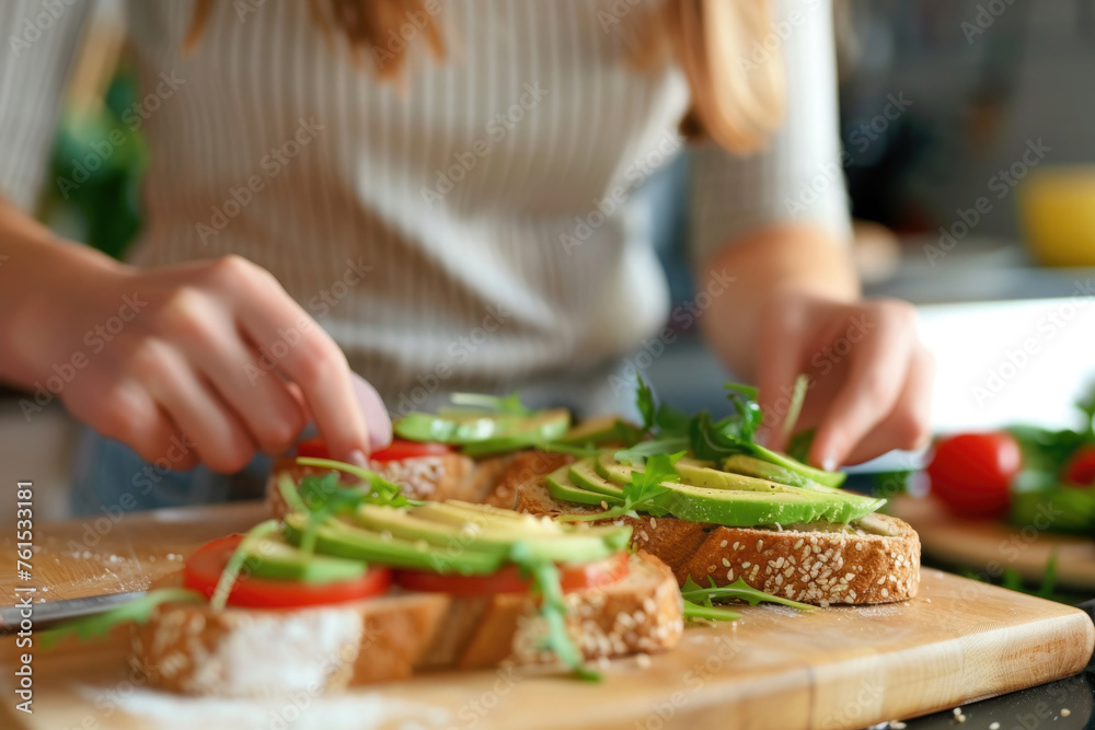 close-up, girl preparing sandwiches with avocado, slices of vegetables on bread, vegetarian breakfast