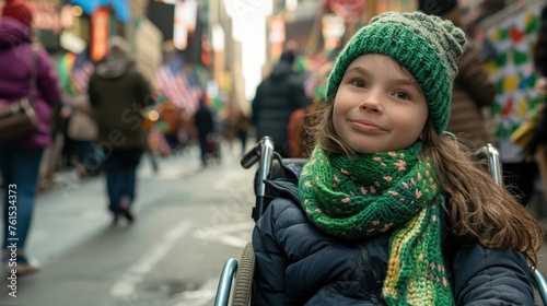 A girl in a wheelchair wearing a green scarf on the street watches the parade. © chutikan