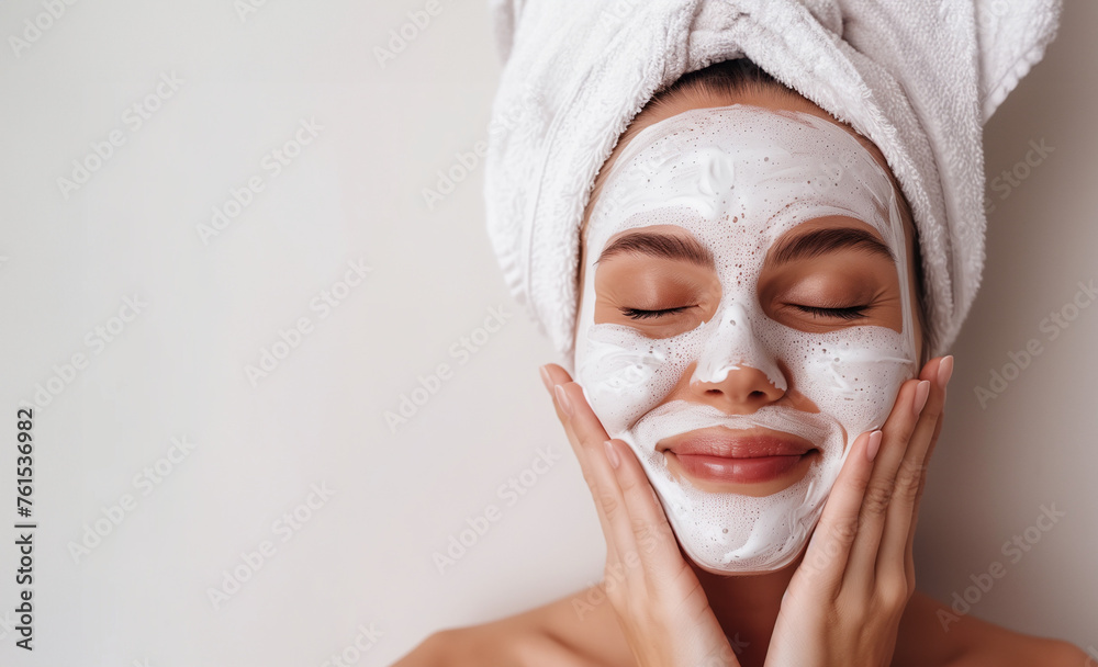 woman wearing facial mask on face wearing towel in hair at spa, clean makeup free isolated on plain light white studio background with copy space