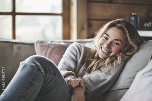 Smiling girl enjoying day off lying on the couch  home concept  Relaxing woman