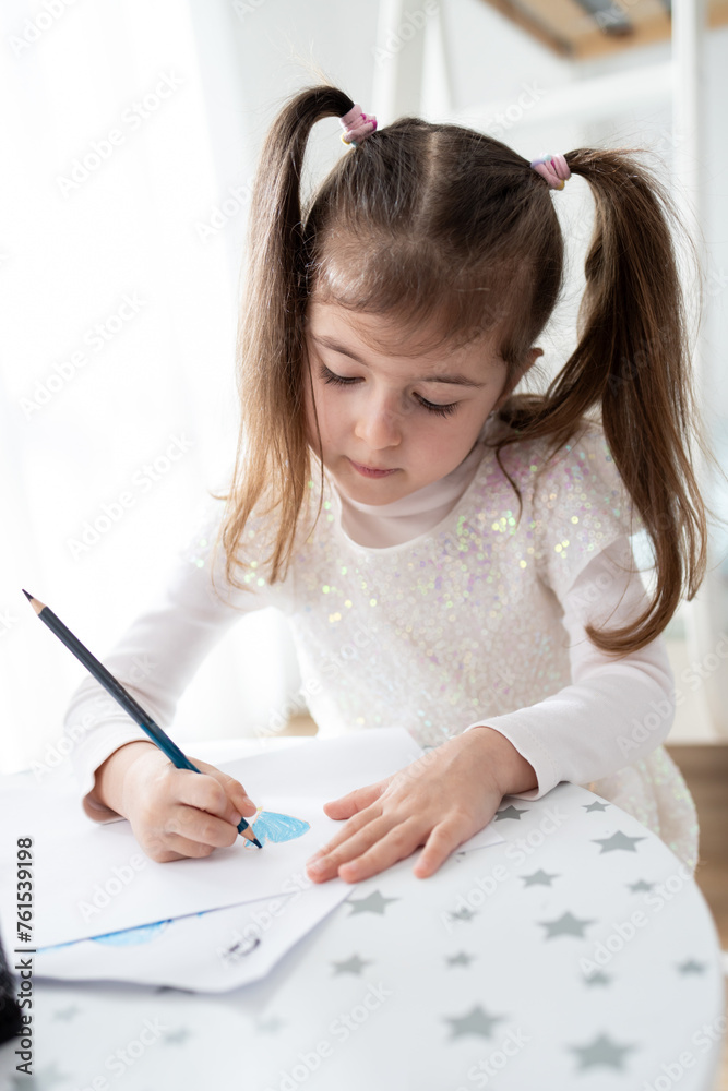 Cute little girl enjoys painting. Girl drawing and coloring picture with color pencil in her room at home Cute little girl enjoys painting. Girl drawing and coloring picture with color pencil in her room at home