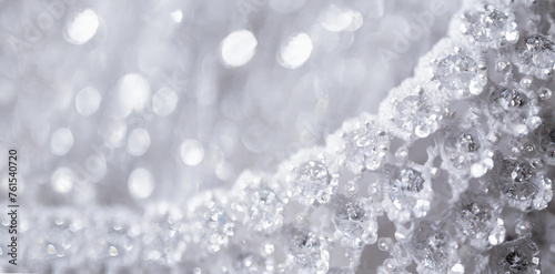 White fabric decorated close up. Elegant drape, angular image and blurred, shimmering background. 