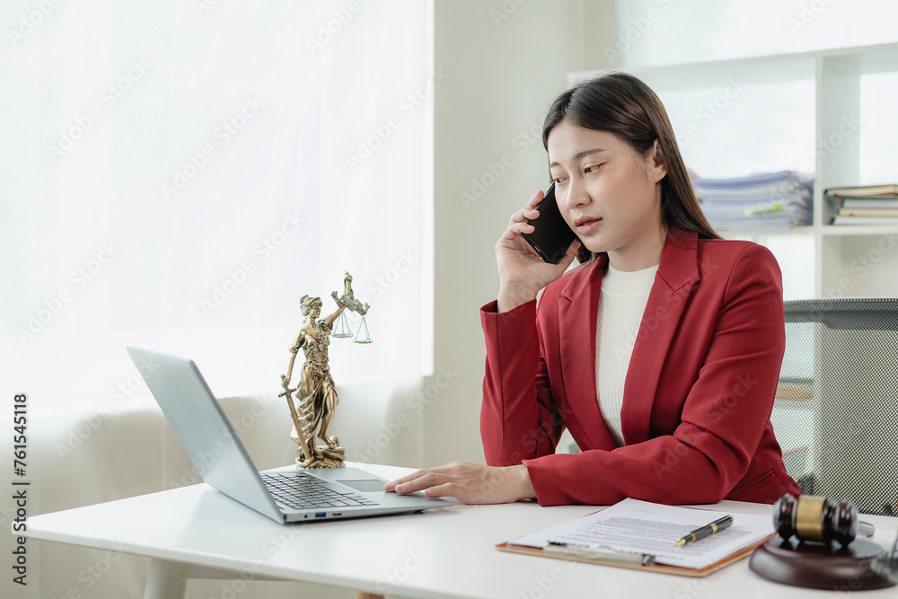 Obraz premium Asian female lawyer working in office or court with hammer and justice pad on table, online legal advice with new laws of real estate business. Law, legal service, advice, justice.