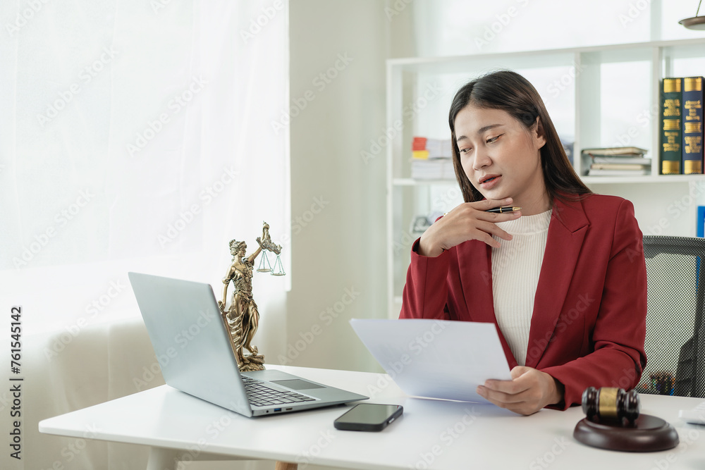 Asian female lawyer working in office or court with hammer and justice pad on table, online legal advice with new laws of real estate business. Law, legal service, advice, justice. Asian female lawyer working in office or court with hammer and justice pad on table, online legal advice with new laws of real estate business. Law, legal service, advice, justice.