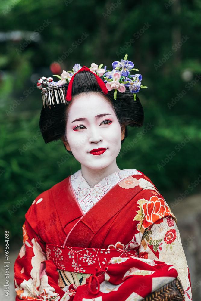 In the tranquility of a Kyoto street, a Geisha in a detailed kimono ...