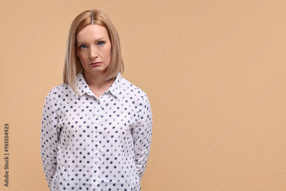 Portrait of sad woman on beige background. Space for text Portrait of sad woman on beige background. Space for text