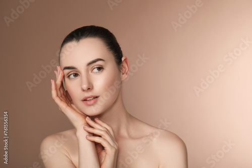 Portrait of beautiful young woman on light brown background. Space for text