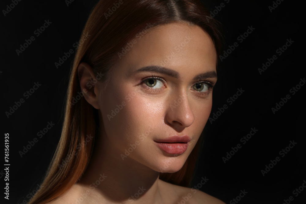 Fototapeta premium Evil eye. Young woman with scary eyes on black background