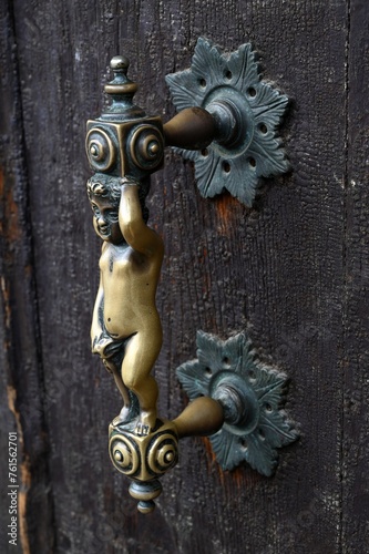 Vieille poignée de porte avec une statuette en bronze d'une porte de maison vénitienne en gros plan