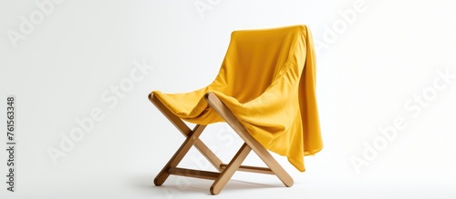 Scandinavian folding chair with yellow slipcover folded on white background. photo