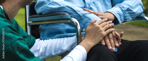 Close up care taker holding elderly man's hand to encourage in senior home care