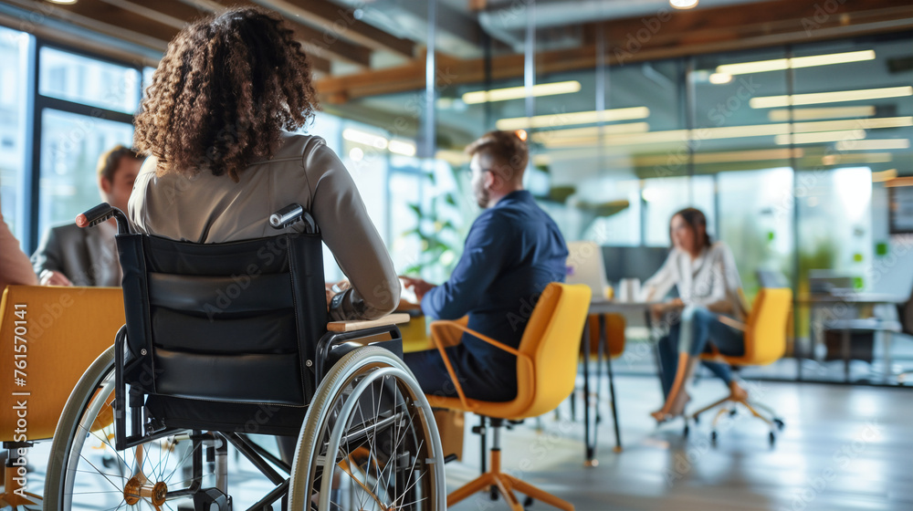 Professionals gather around a table for a meeting, including an individual in a wheelchair, showcasing a workplace that values diversity and accessibility Professionals gather around a table for a meeting, including an individual in a wheelchair, showcasing a workplace that values diversity and accessibility