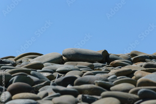 Obraz na płótnie Gray stones on the seashore against the blue sky w salonie