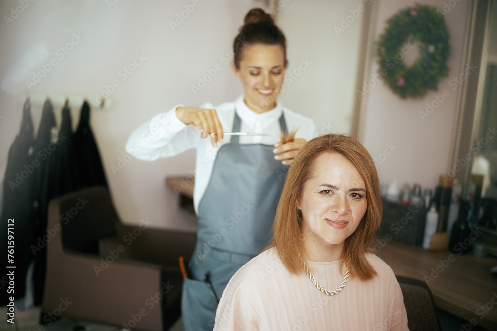 woman hair salon employee in modern beauty studio cutting hair woman hair salon employee in modern beauty studio cutting hair