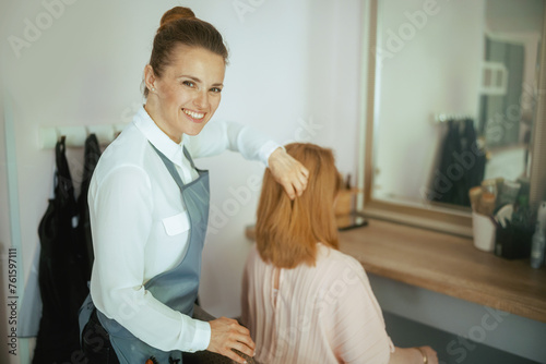 woman hairdresser in modern hair studio with client
