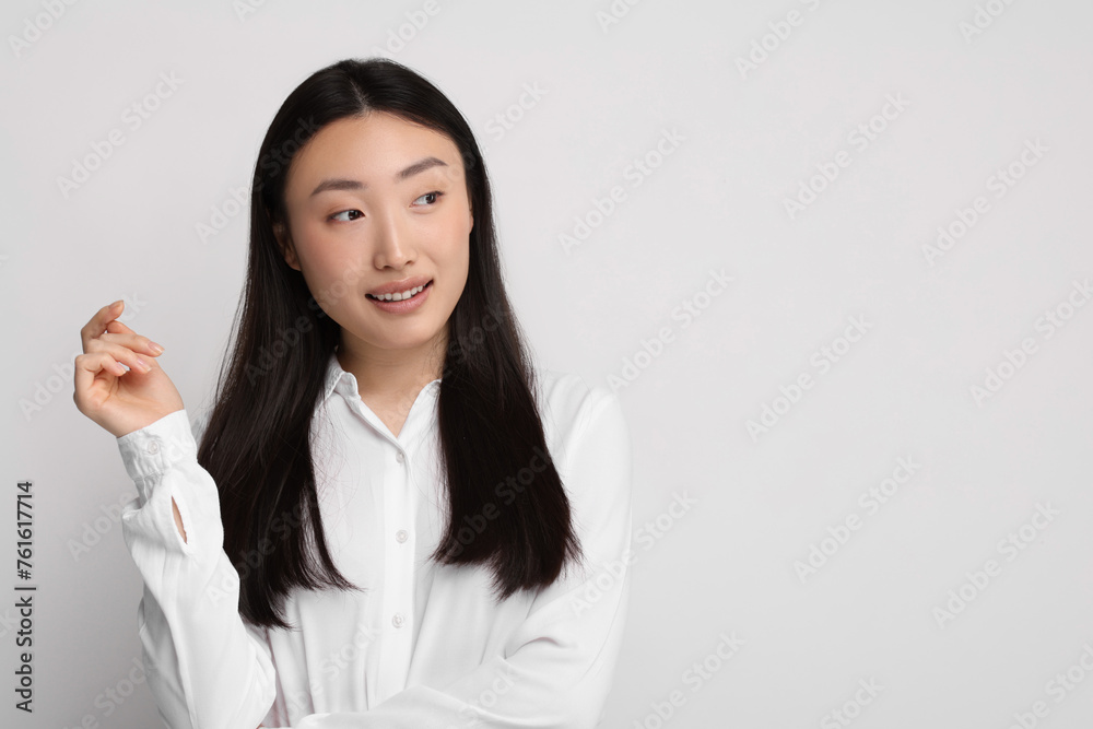 Portrait of smiling woman on light background. Space for text Portrait of smiling woman on light background. Space for text