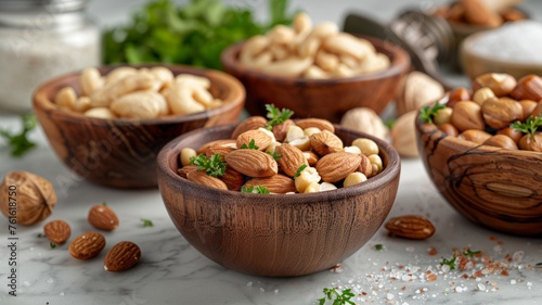 Three bowls with almonds and cashews on a table