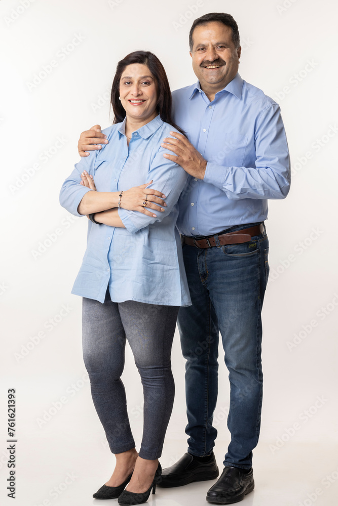 Portrait of smiling Indian couple with arms around on white background Portrait of smiling Indian couple with arms around on white background