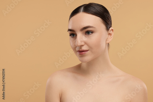 Portrait of beautiful woman on beige background. Space for text