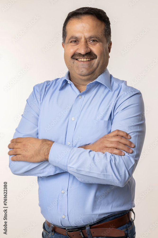 Happy mature man with arms crossed and looking at camera while standing against white background Happy mature man with arms crossed and looking at camera while standing against white background