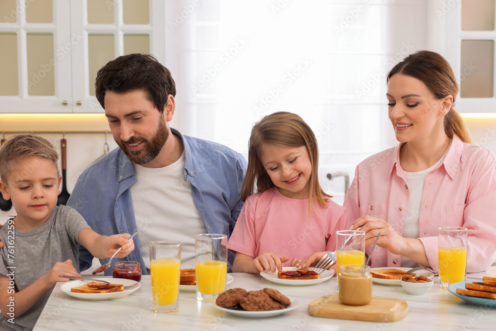 Happy family having breakfast at table in kitchen Happy family having breakfast at table in kitchen