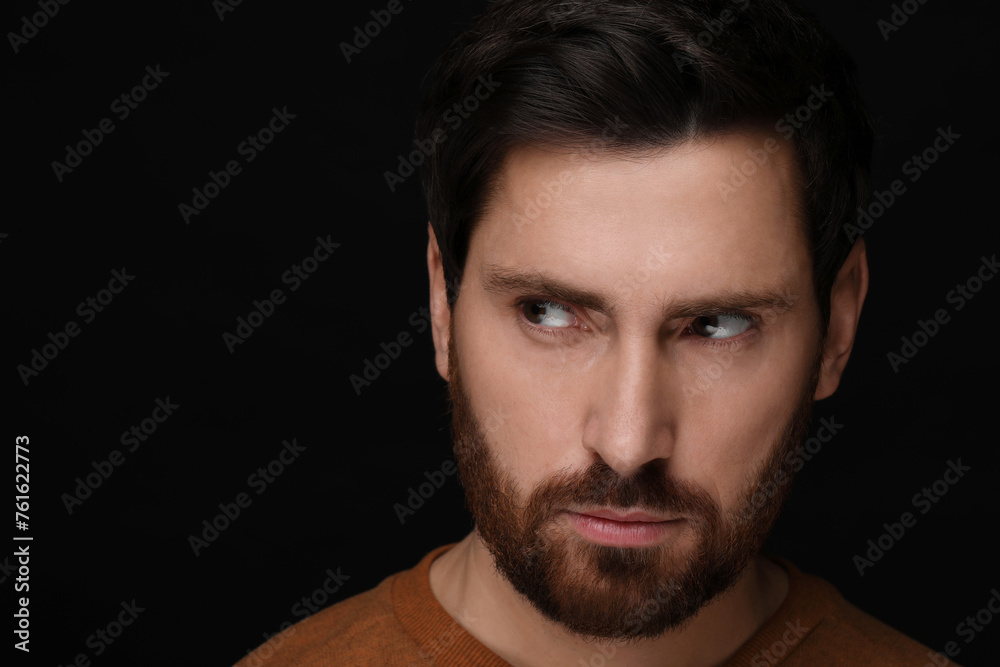 Evil eye. Man with scary eyes on black background, closeup and space for text Evil eye. Man with scary eyes on black background, closeup and space for text