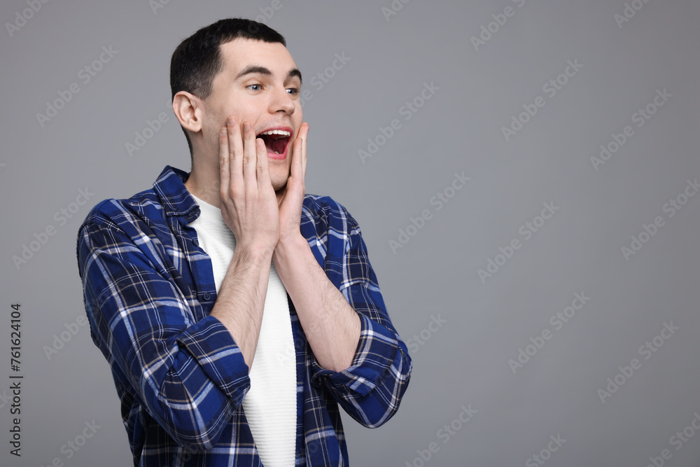 Portrait of surprised man on grey background, space for text Portrait of surprised man on grey background, space for text