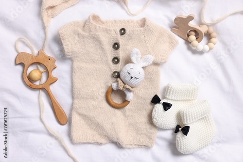 Different baby accessories on white fabric, flat lay