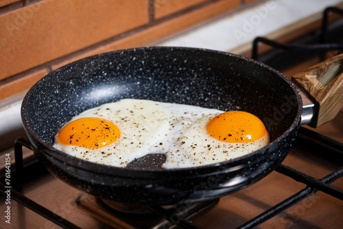 two fried eggs in a frying pan on the kitchen stove © cook_inspire