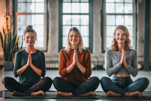 Group yoga class show relaxation and wellness, Three women are meditate a mat in a room, each with their hands in their laps,smiling,enjoying their time together. peaceful and relaxing
