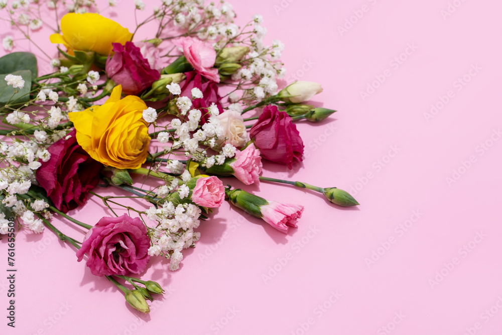 Vibrant flowers spread out on a pink background for a joyous visual Vibrant flowers spread out on a pink background for a joyous visual