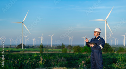 engineers working and holding the report at wind turbine farm Power Generator Station on mountain,Thailand people,Technician man and woman discuss about work © reewungjunerr