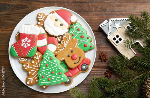 Different tasty Christmas cookies and festive decor on wooden table, flat lay