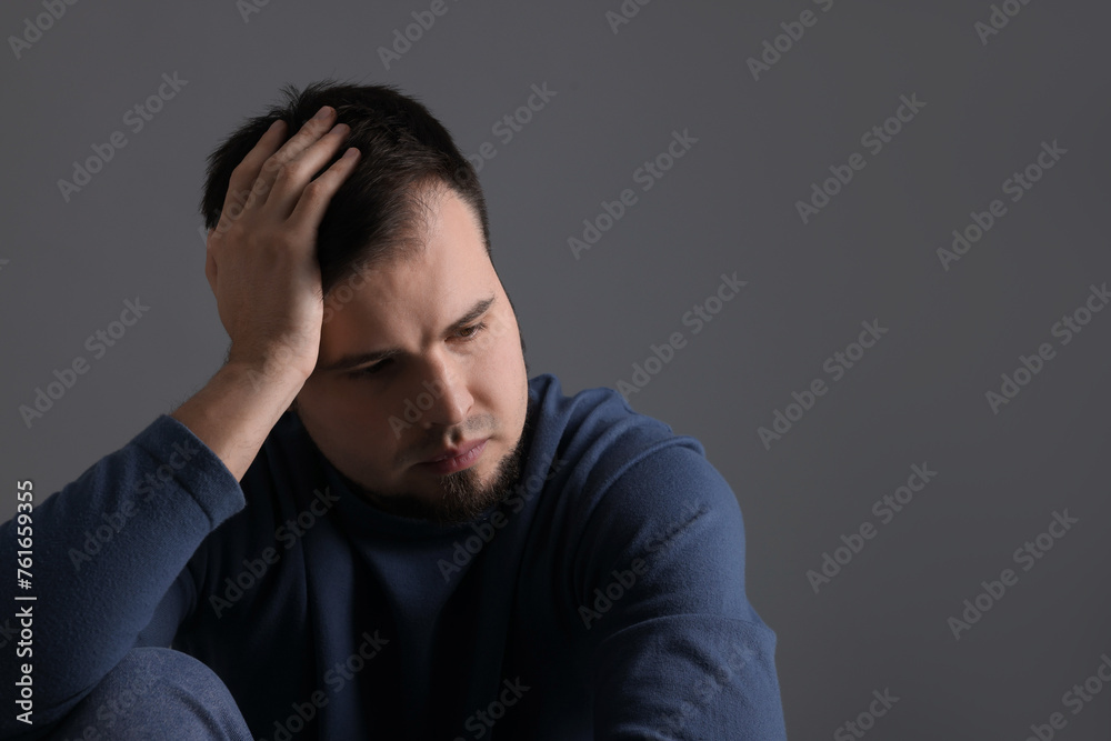 Portrait of sad man on dark grey background Portrait of sad man on dark grey background