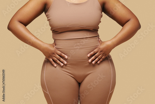 Cropped image of curvy Black woman putting hands on waist photo