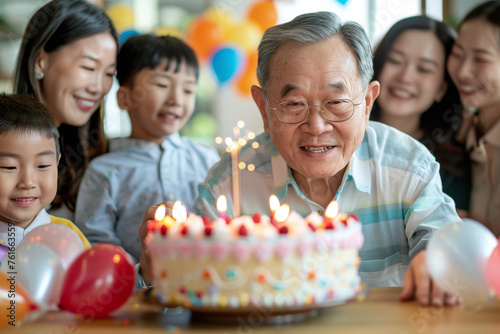 Happy three generation asian family celebrating grandpa's birthday at home.